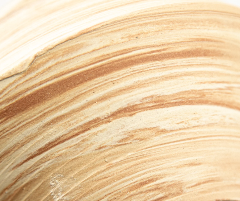 Gros plan sur le marbrage de la tasse Jupiter 04 : bandes sable, crème et ocre mélangées par le tournage